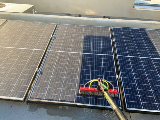 Three solar panels side by side: the left panel is covered in grey dust, the middle panel is half cleaned, and the right panel is clean and deep blue